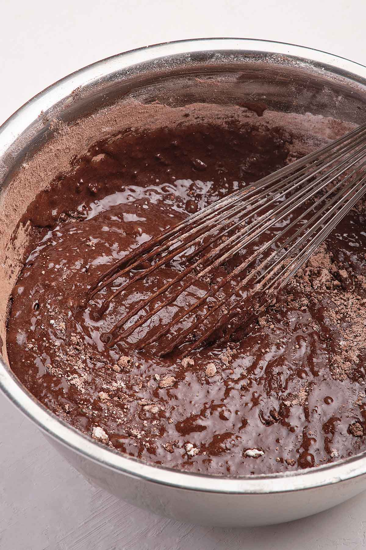 chocolate cake batter in a bowl with a whisk. 