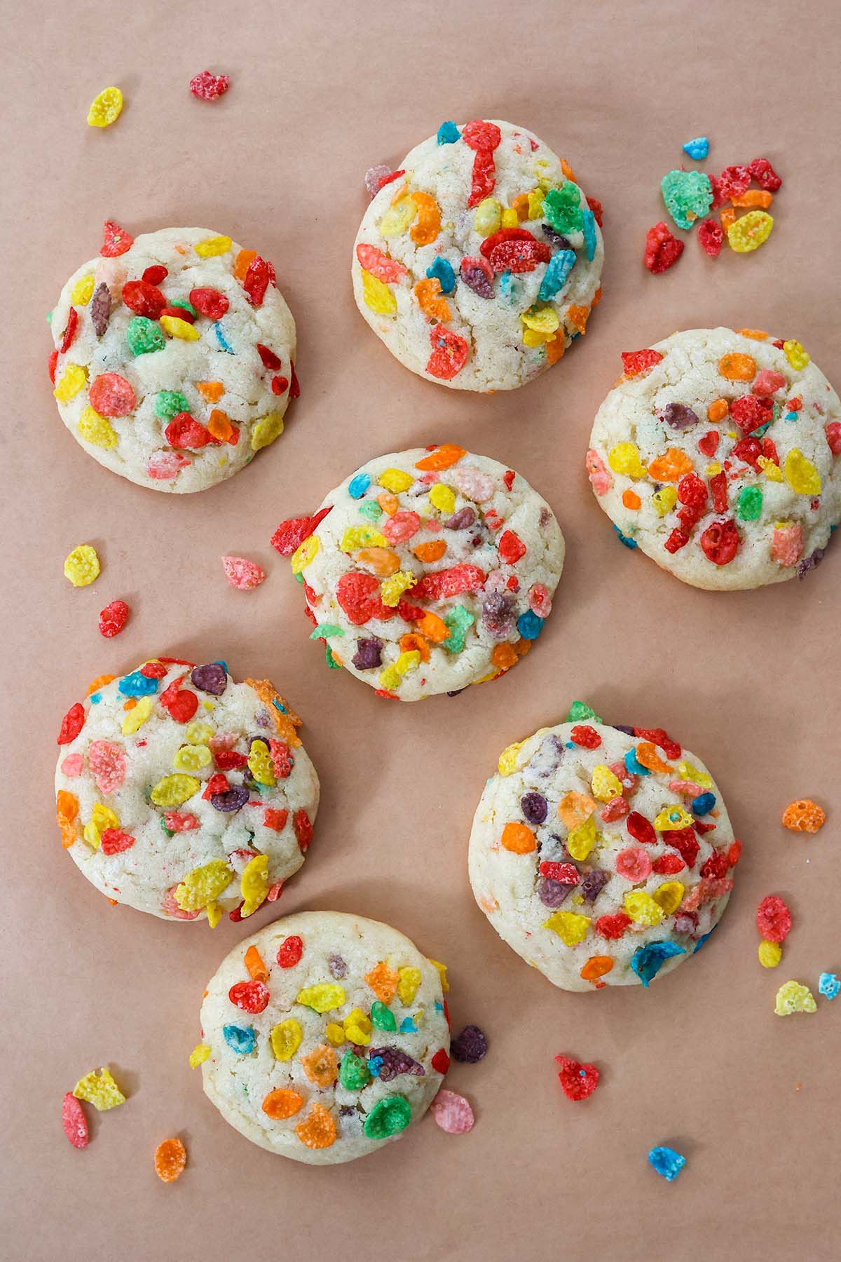 seven fruity pebbles cookies up close with cereal on the side. 