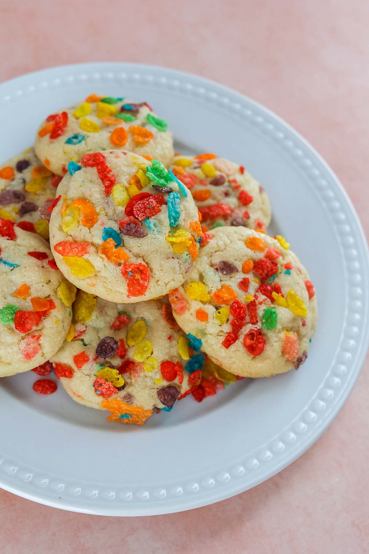 fruity pebbles cookies on a white plate. 