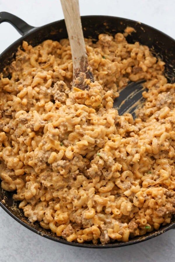 hamburger helper in a skillet with a wooden spoon.