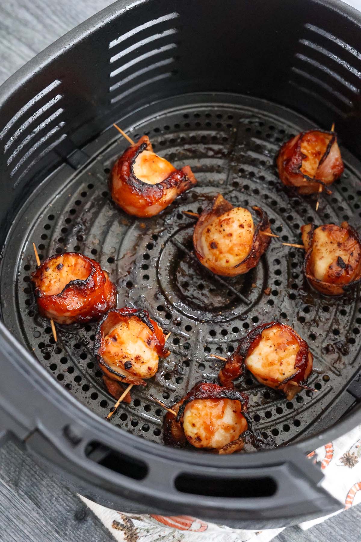 cooked bbq bacon wrapped scallops in the air fryer basket.