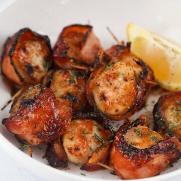 air fryer bbq bacon wrapped scallops with a lemon wedge.