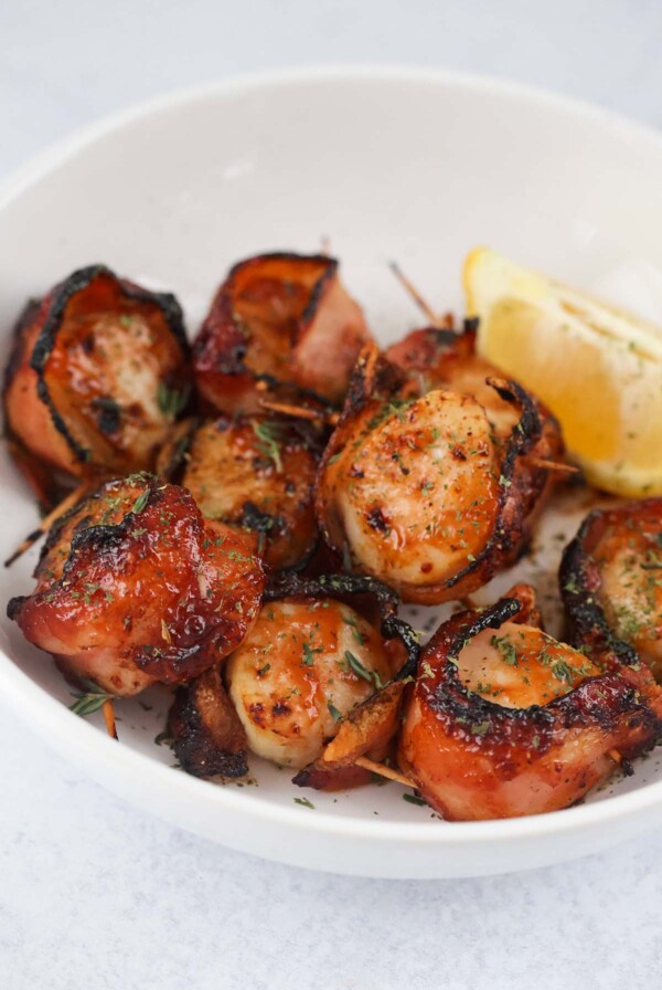 air fryer bbq bacon wrapped scallops with a lemon wedge.
