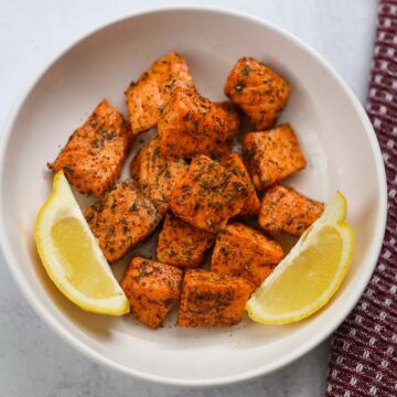 air fryer salmon bites with lemon wedges.