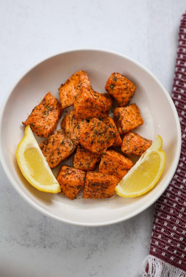 air fryer salmon bites with lemon wedges.