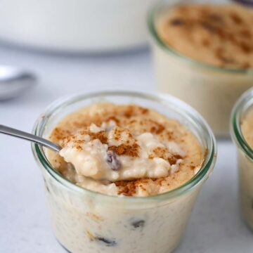 arroz con dulce in a small glass jar with a spoon.