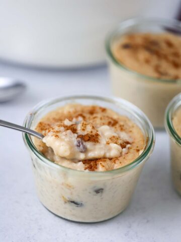 arroz con dulce in a small glass jar with a spoon.
