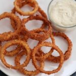 Crispy onion rings with spicy aioli on the side.