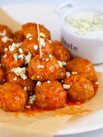 honey buffalo chicken meatballs with blue cheese crumbles on top.
