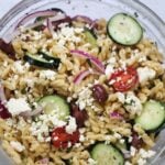 Greek pasta salad in a large glass bowl.