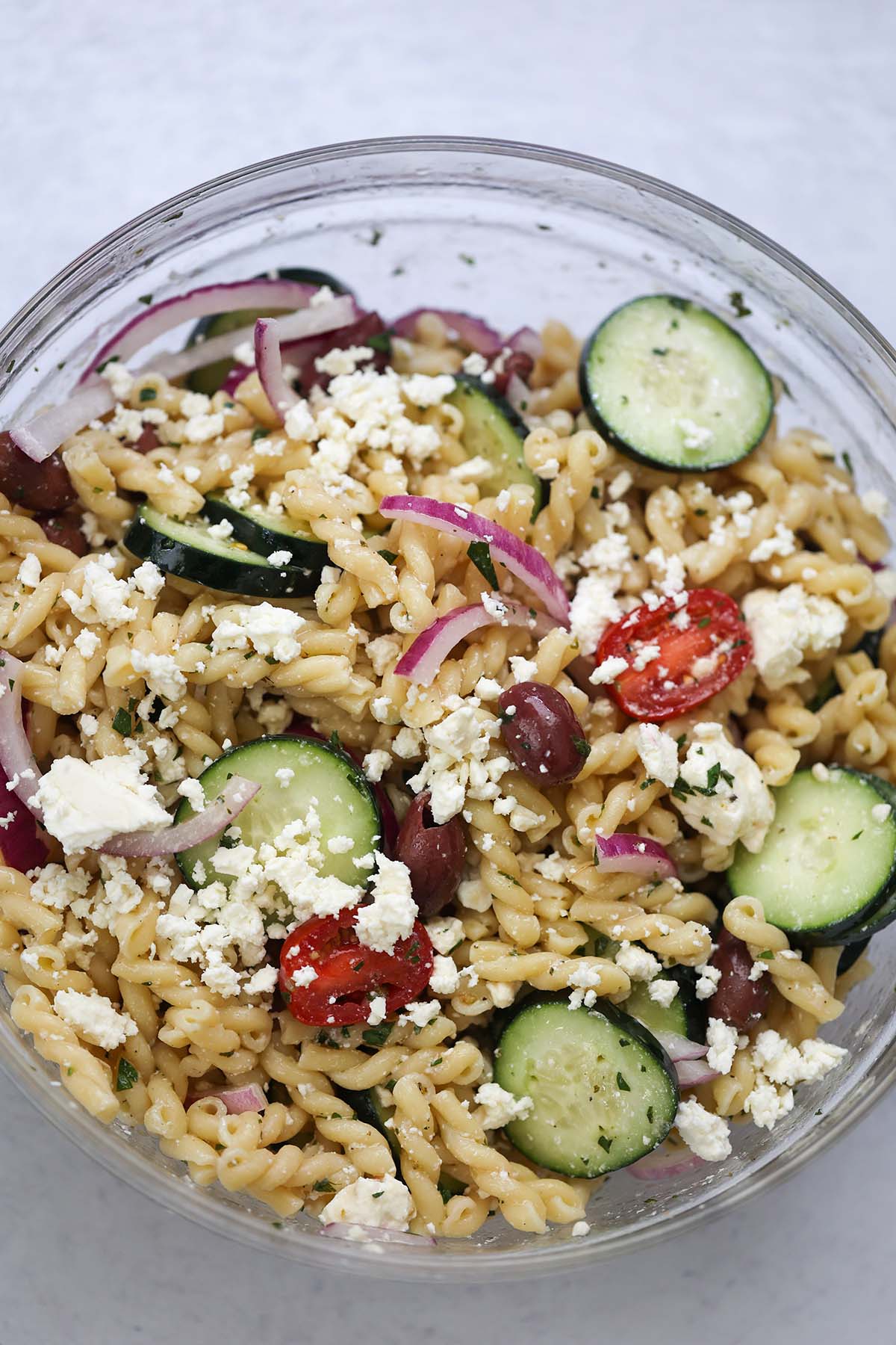 Greek pasta salad in a large glass bowl. 