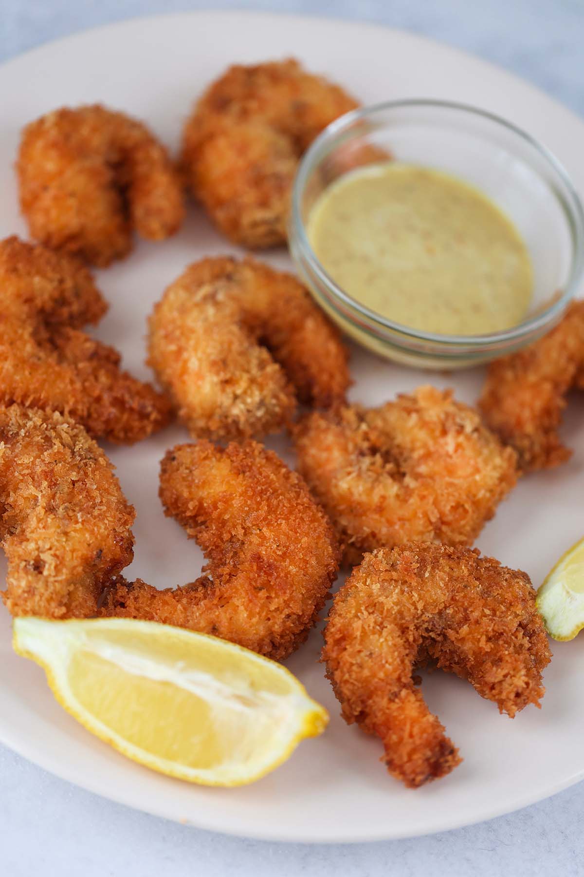 crunchy panko shrimp with lemon wedges and sauce on the side. 