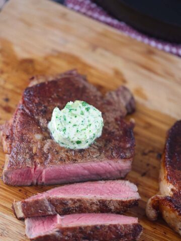 garlic herb compound butter on sliced steak.