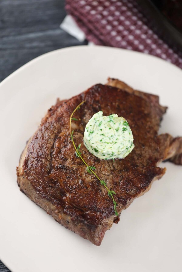 pan-seared ribeye steak with butter and thyme on top.