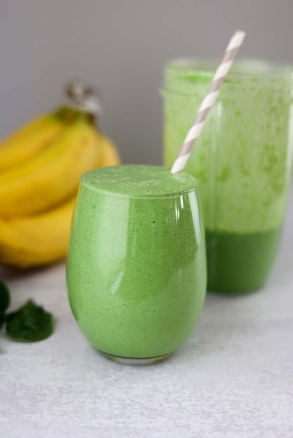 glass filled with green spinach banana smoothie.