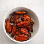 air fryer honey bbq wings on a white plate.