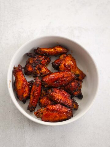 air fryer honey bbq wings on a white plate.