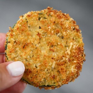 hand holding an air fryer zucchini chip up close.