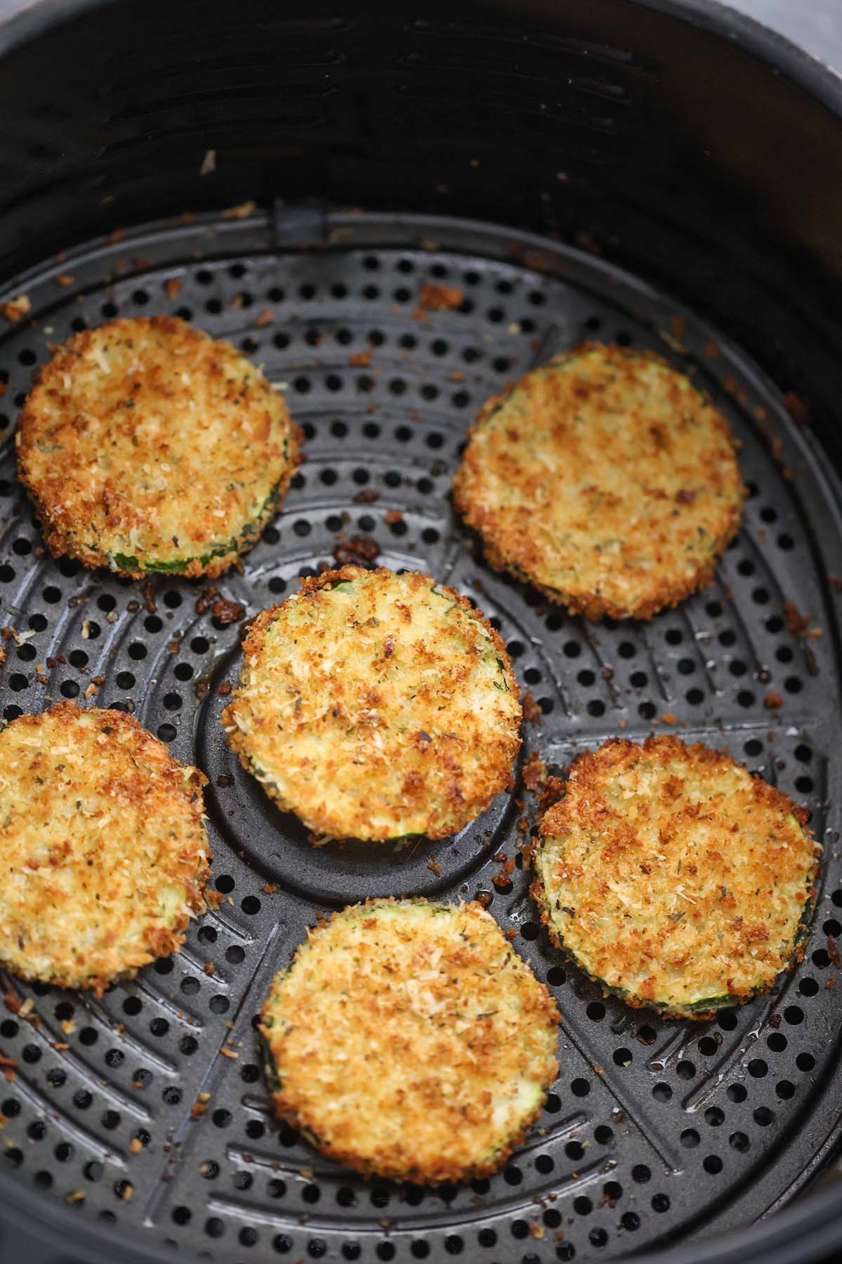 six cooked zucchini chips in the air fryer. 