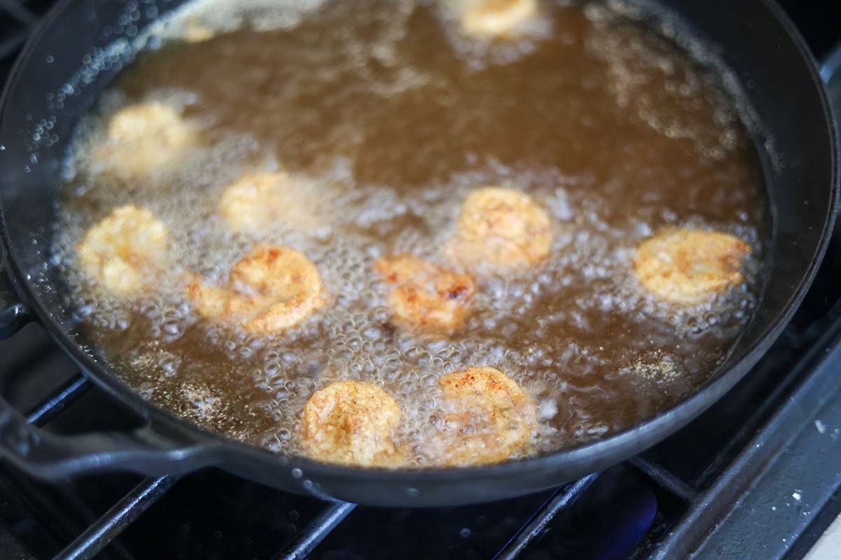 shrimp frying in a skillet with oil. 