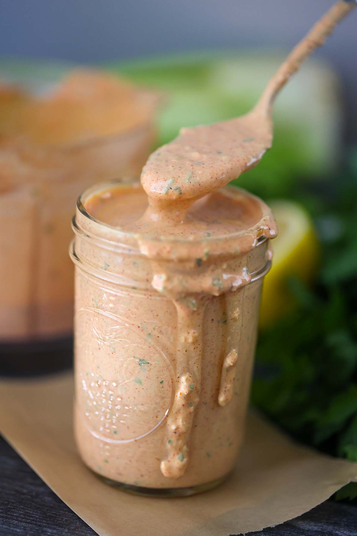 A spoonful of remoulade sauce over a filled mason jar. 