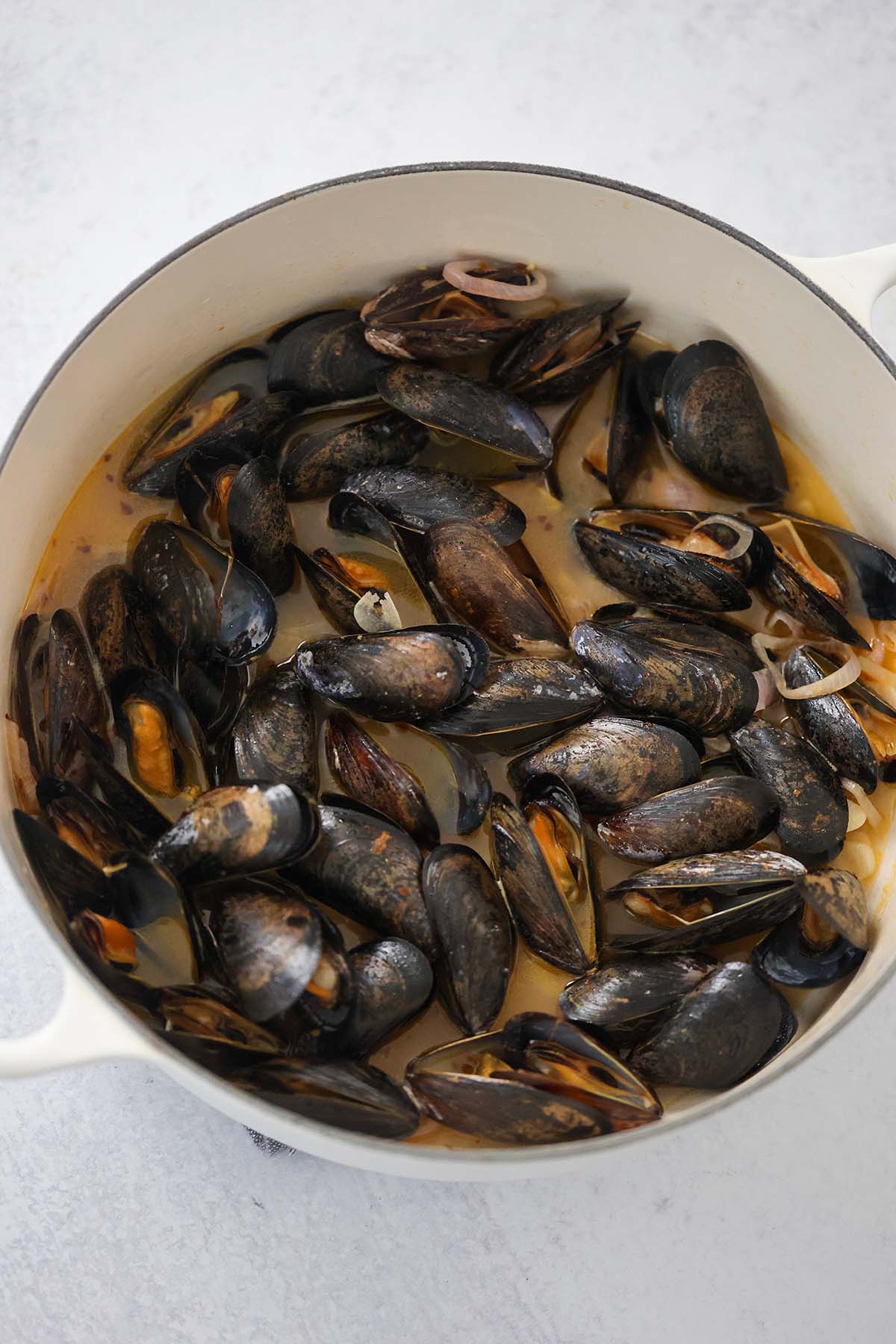 steamed black mussels with lobster broth in a pot. 