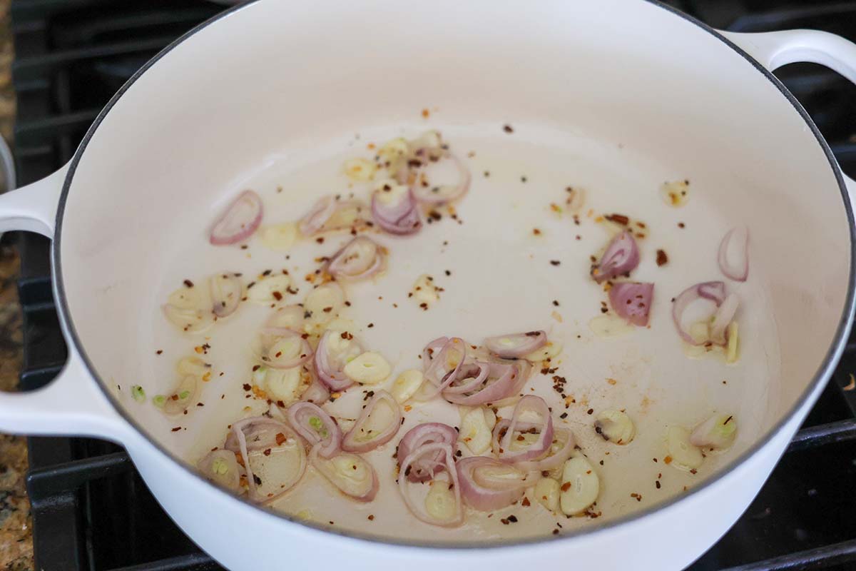 olive oil, shallots, garlic, and red pepper flakes in a large white pot. 