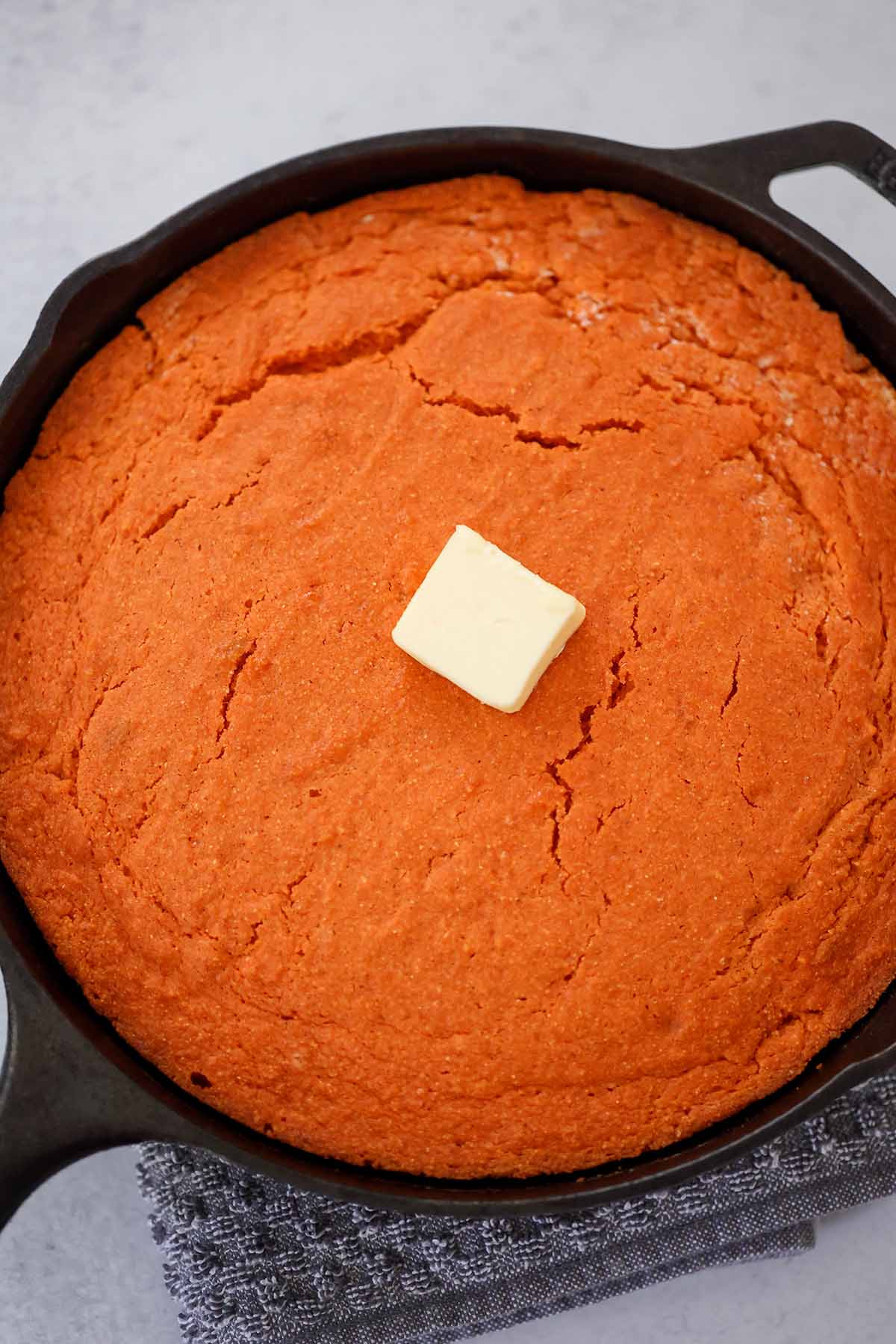 sweet potato cornbread with butter in a skillet. 