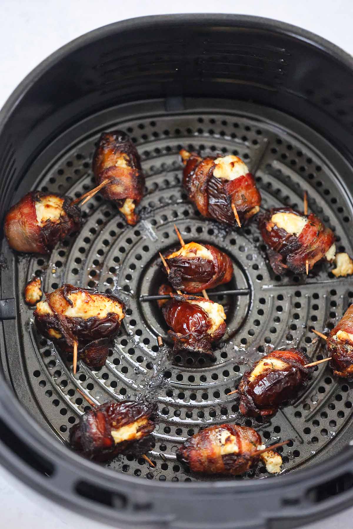 goat cheese bacon wrapped dates in the air fryer basket. 
