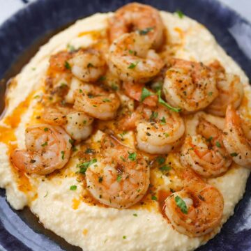 spicy shrimp and grits on a blue plate.