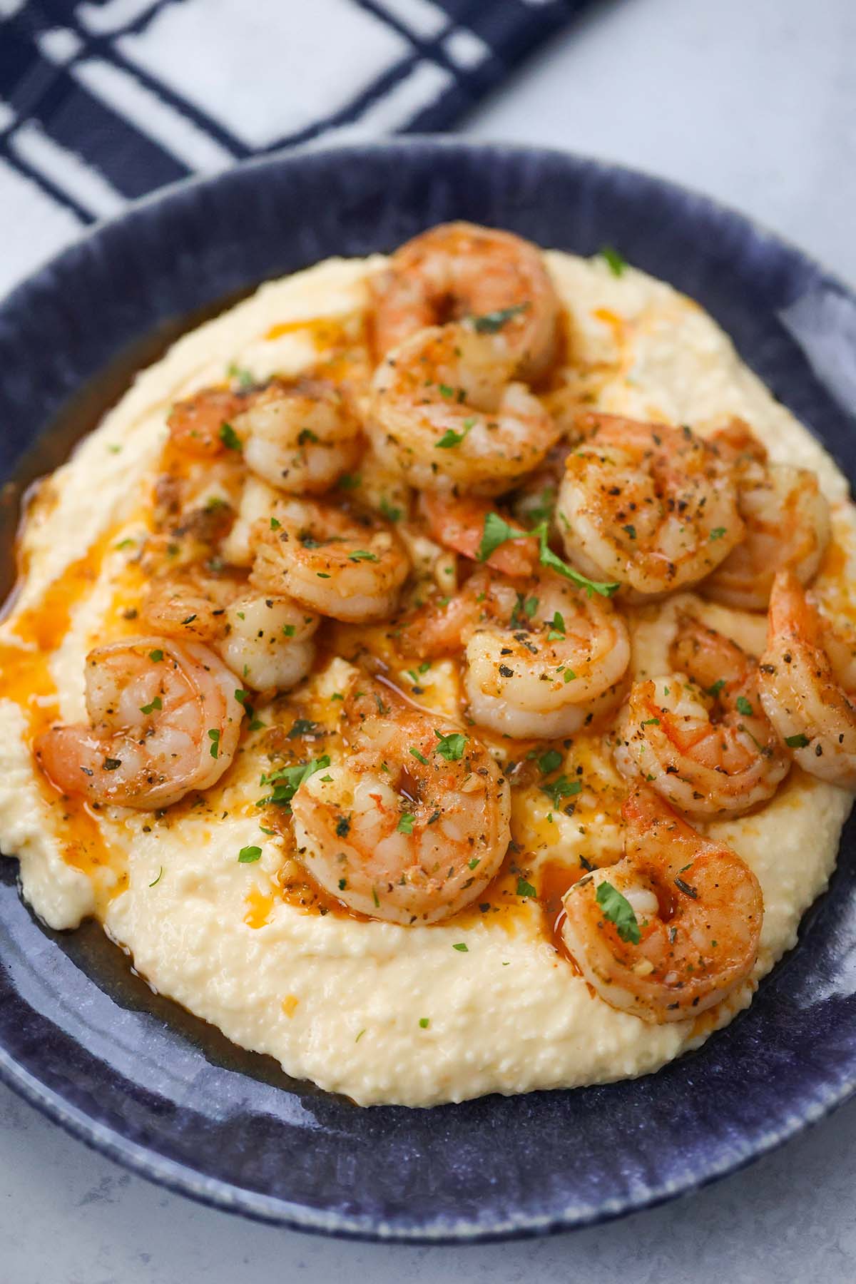 spicy shrimp and grits on a blue plate. 