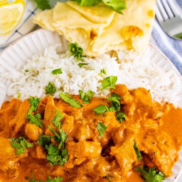butter chicken with rice and naan on the side.