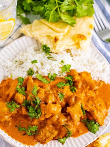 butter chicken with rice and naan on the side.