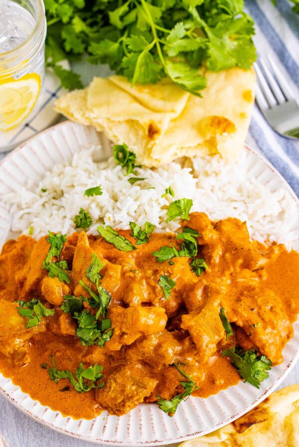 butter chicken with rice and naan on the side.