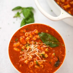 pasta fagioli soup in a bowl with a pot on the side.