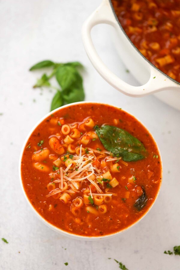 pasta fagioli soup in a bowl with a pot on the side.
