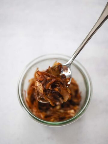 caramelized onions in a bowl with a spoon.