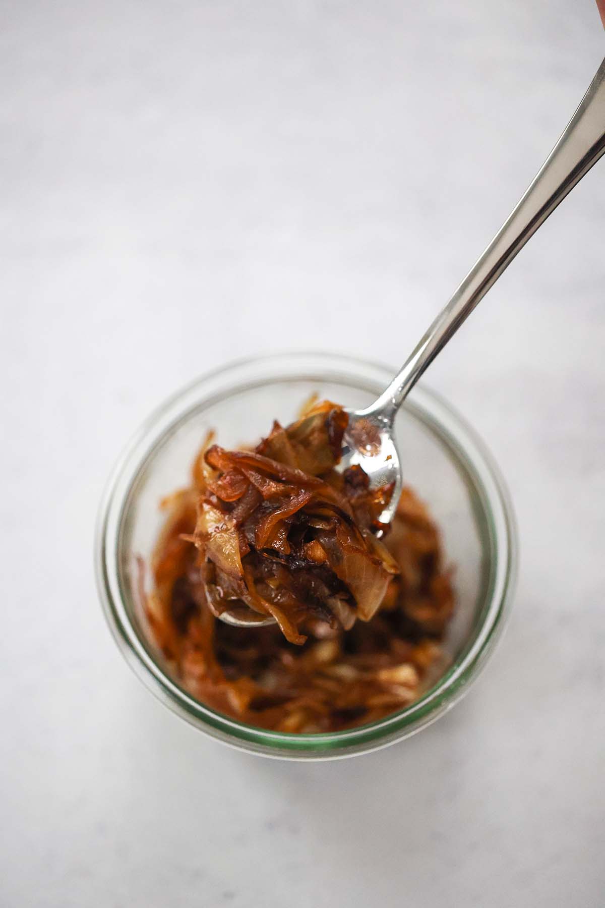 caramelized onions in a bowl with a spoon. 