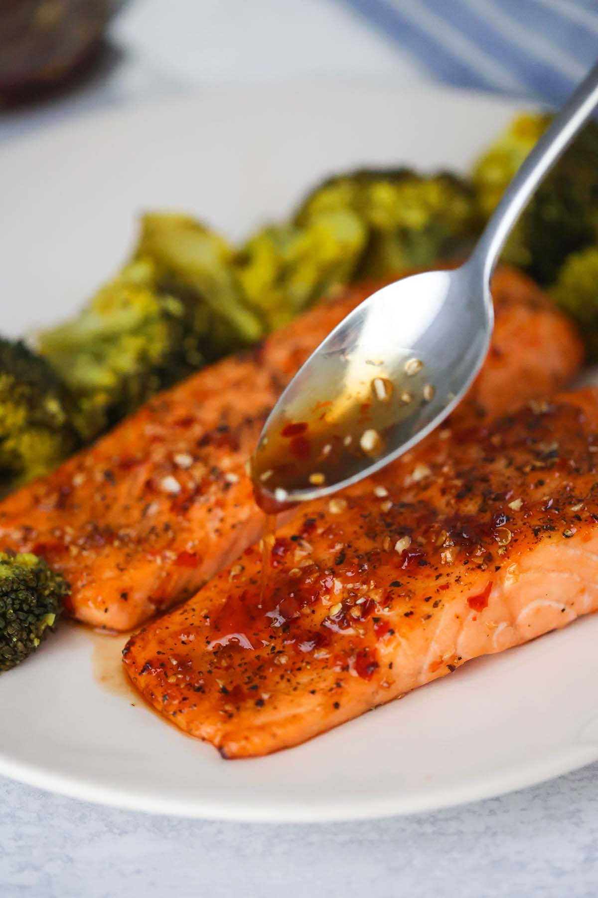 spoon drizzling honey glaze over cooked salmon. 