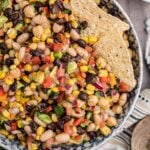 cowboy caviar in a bowl with two tortilla chips.