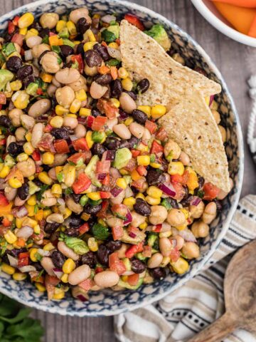 cowboy caviar in a bowl with two tortilla chips.