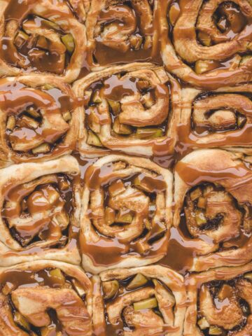 Twelve caramel apple cinnamon rolls up close.