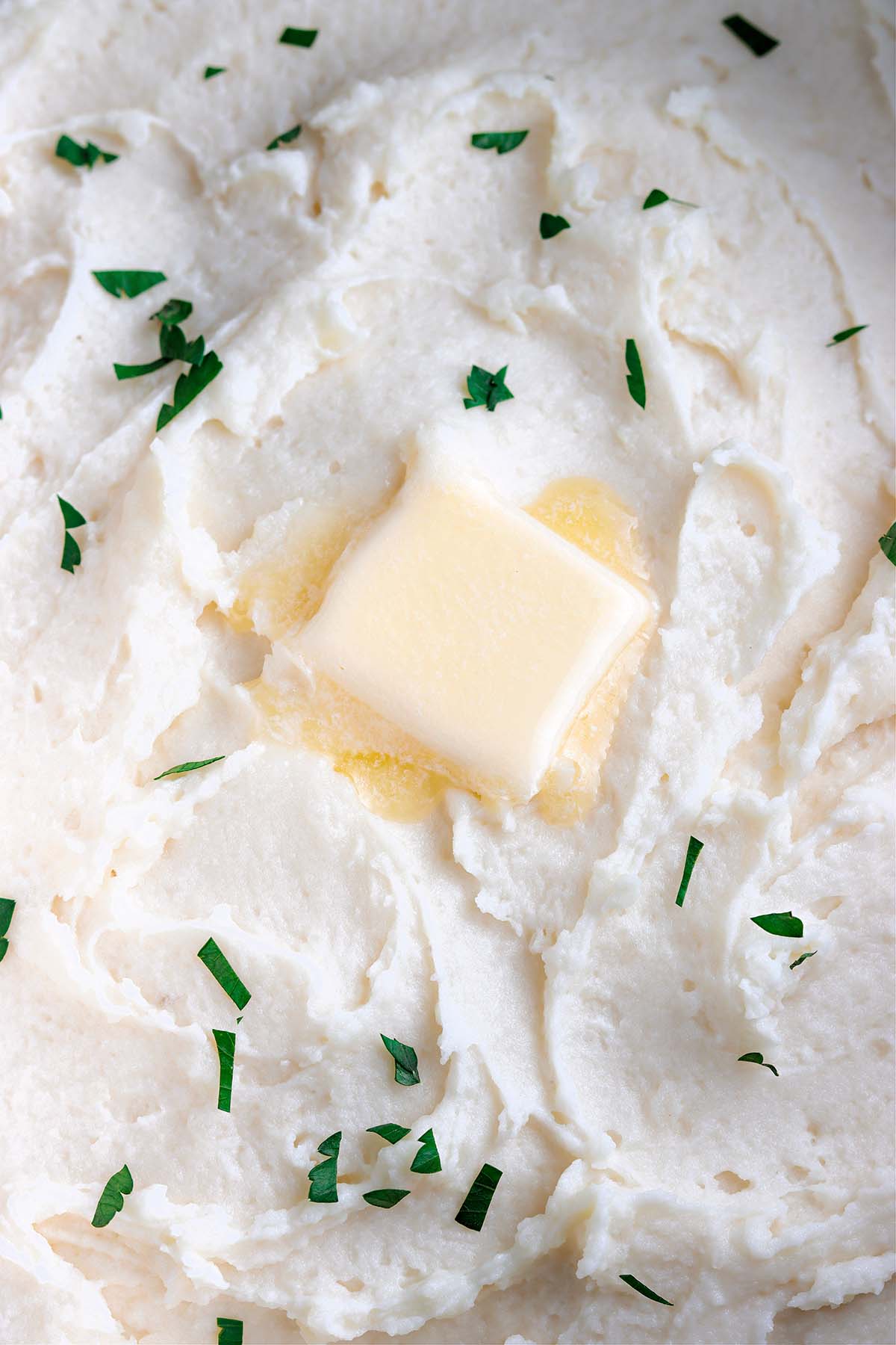mashed potatoes with butter and parsley up close. 