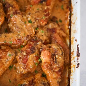 Smothered turkey wings and legs in a baking dish up close.
