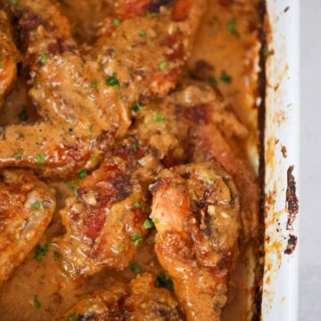 Smothered turkey wings and legs in a baking dish up close.