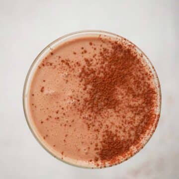 Chocolate coquito in a martini glass up close.