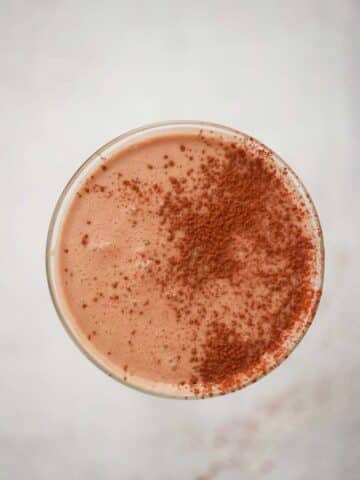 Chocolate coquito in a martini glass up close.