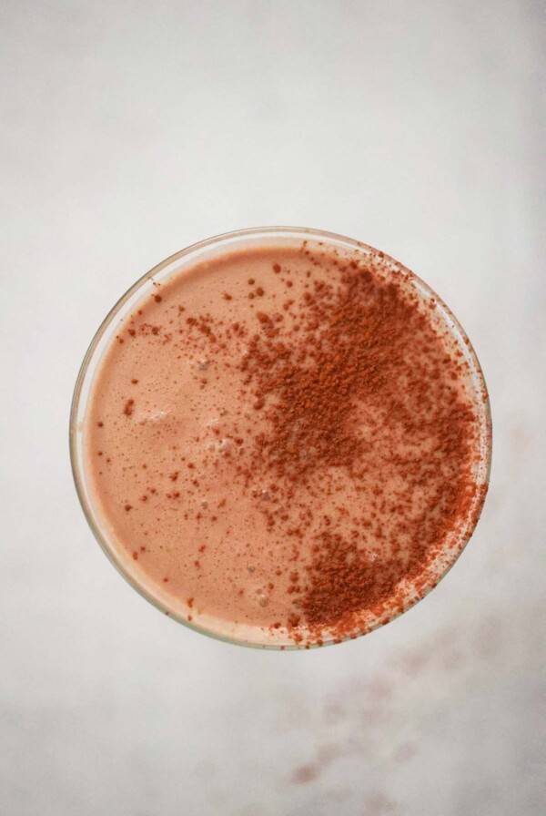 Chocolate coquito in a martini glass up close.