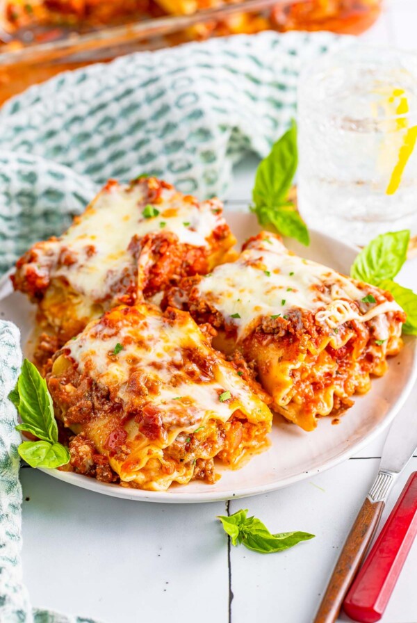 Three lasagna roll ups on a plate.