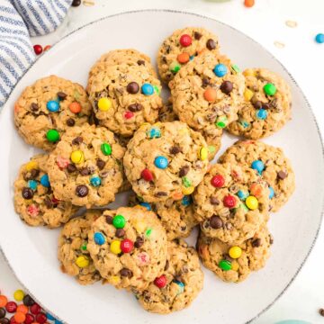 Monster cookies on a plate with milk on the side.